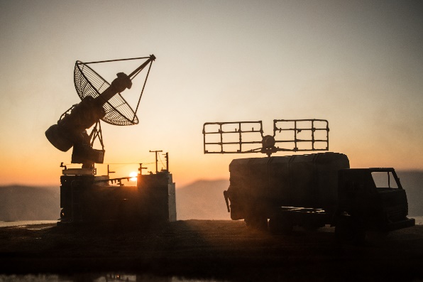Mobile radar systems silhouetted at sunset representing aerospace and defense applications